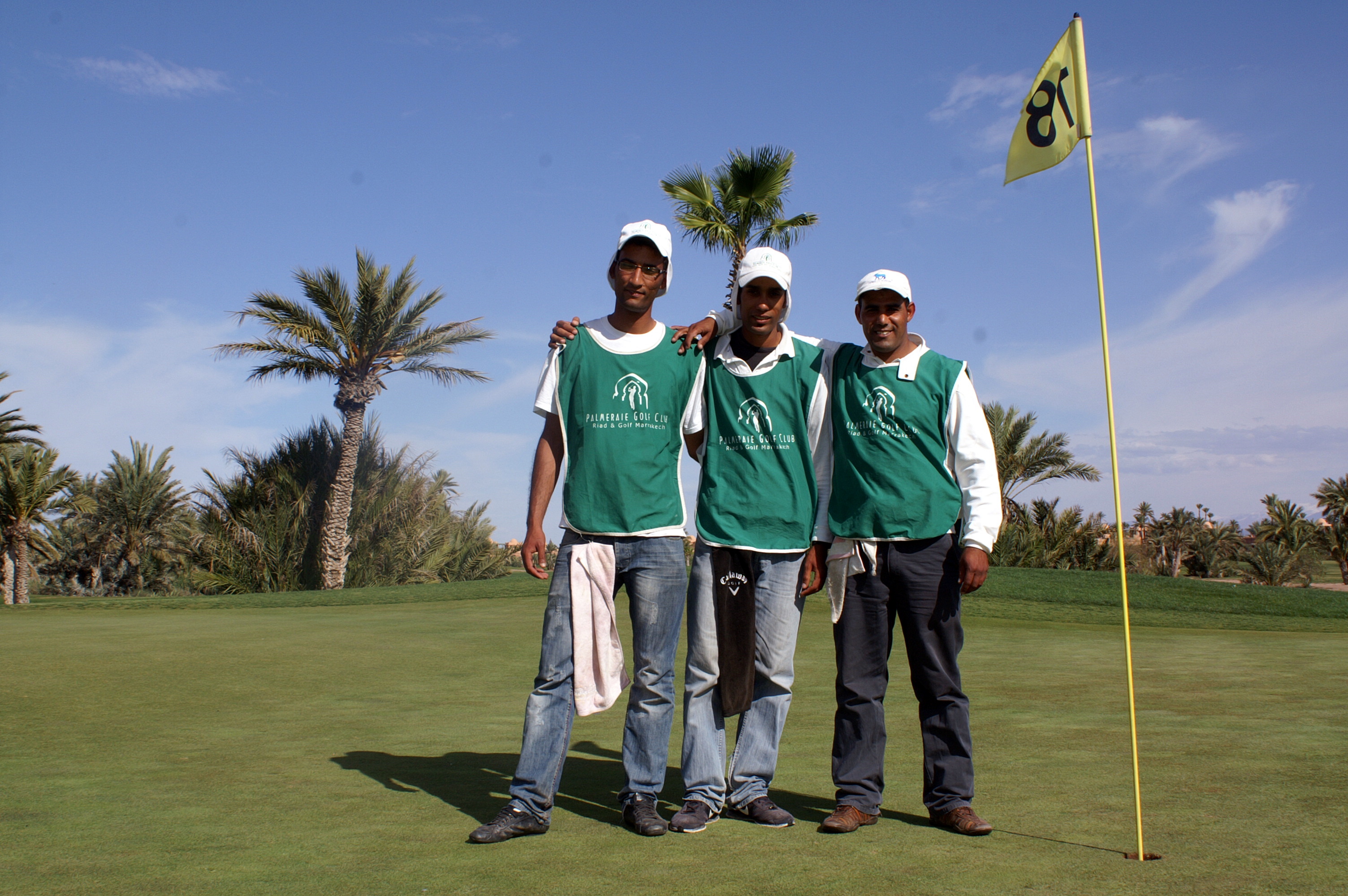 Caddies on green 18 in La Palmeraie golf course in Marrakech, Morocco