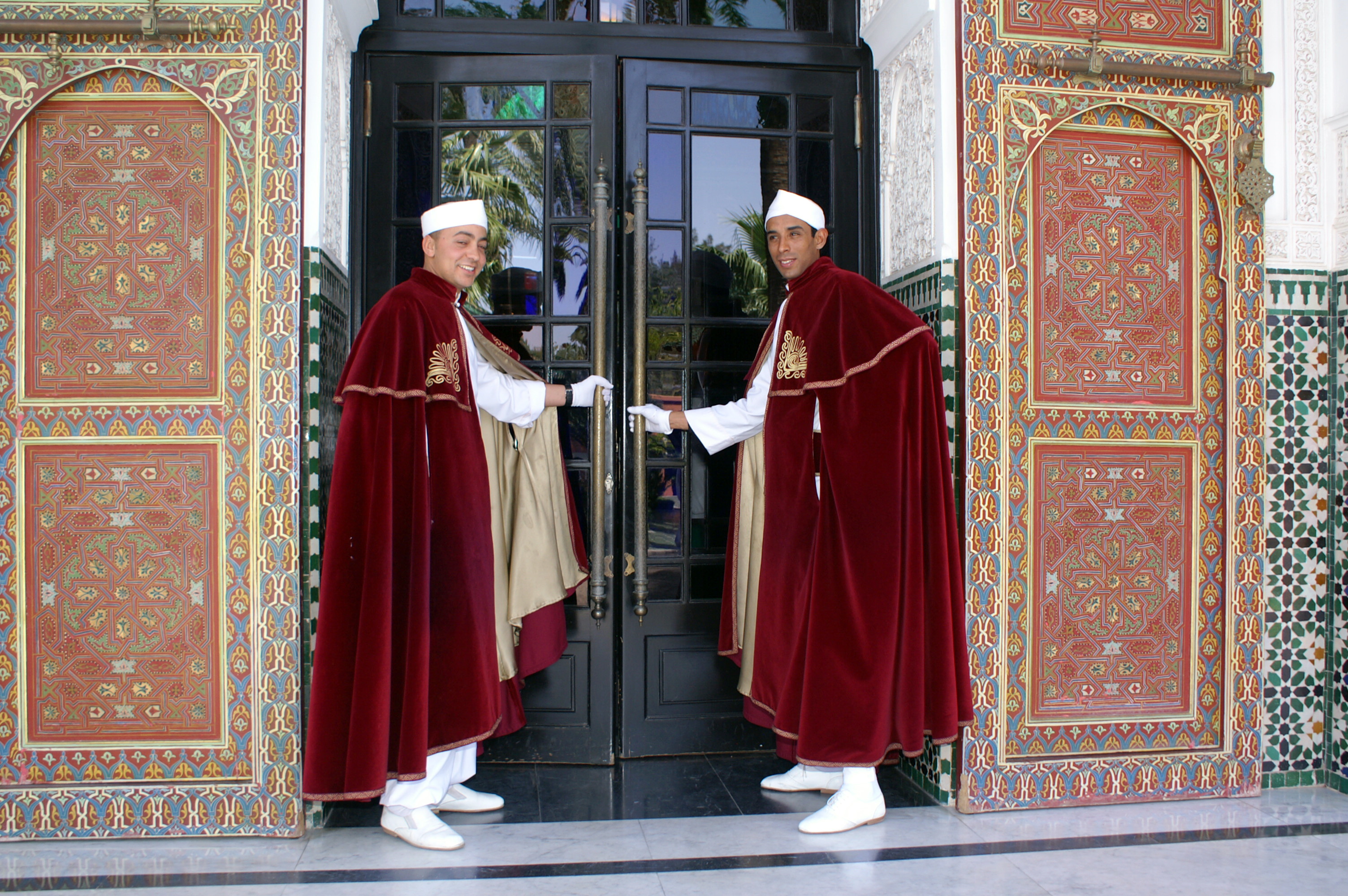 Two out of four doormen about to open the doors