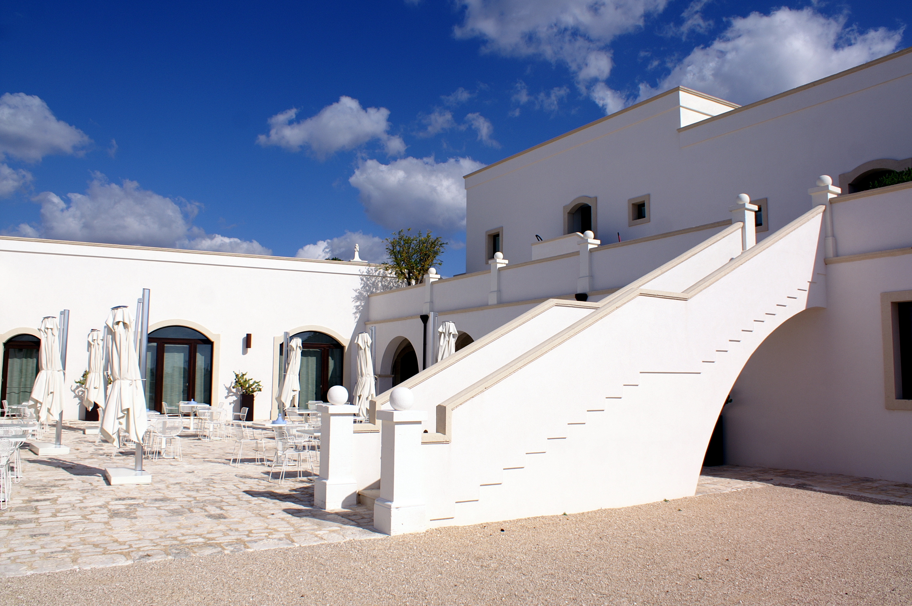 Courtyard stair, tables and upper floor of Masseria Bagnara in Lizzano, Puglia