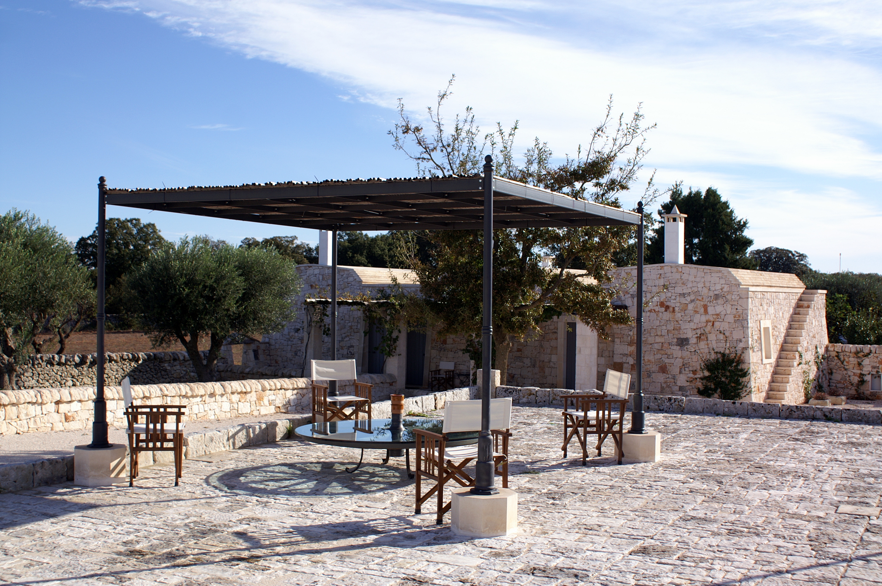 Patio with garden chairs and sunscreen at Masseria Fumarola