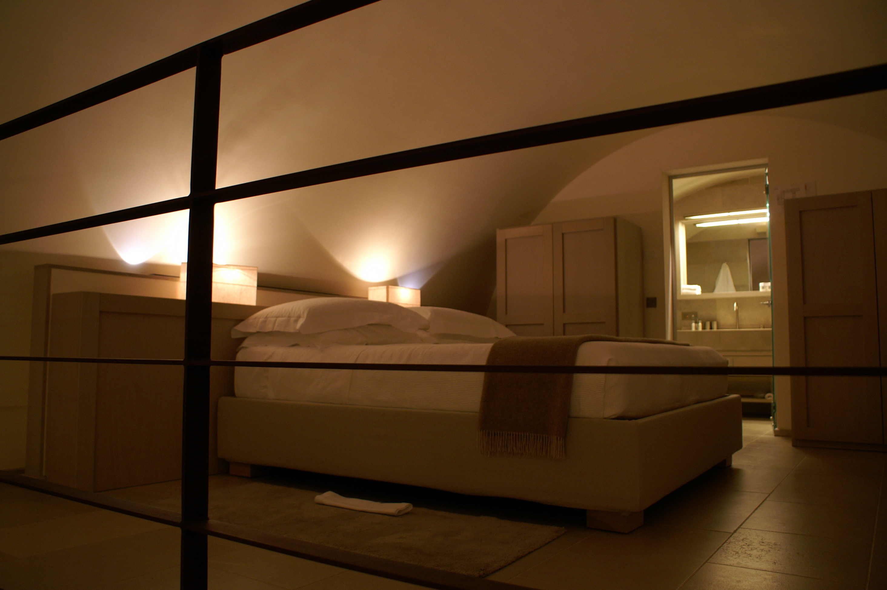 King size bed in upper floor of loft suite by night at Histo Relais near Taranto