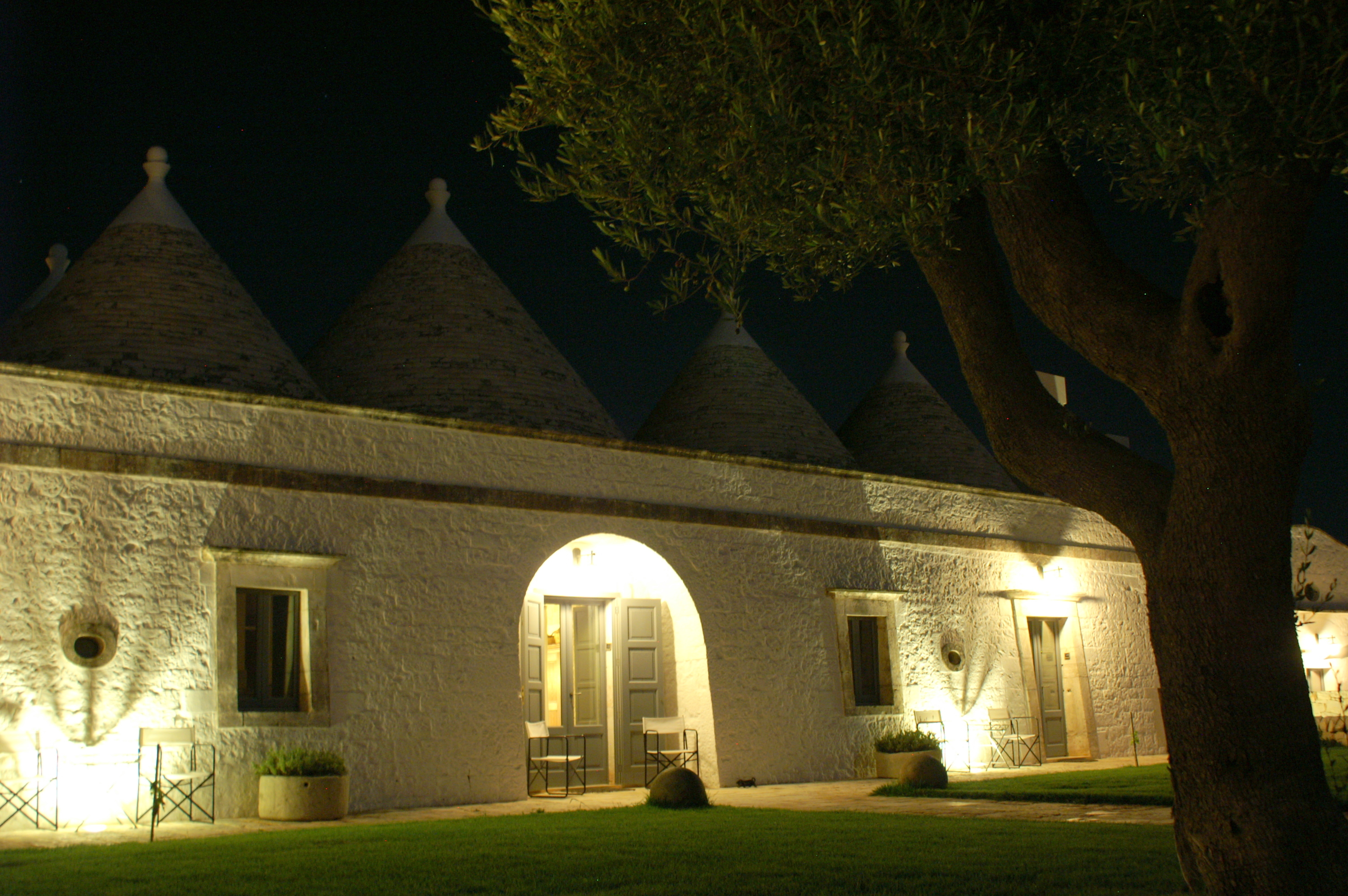 Main trulli building by night at Masseria Fumarola