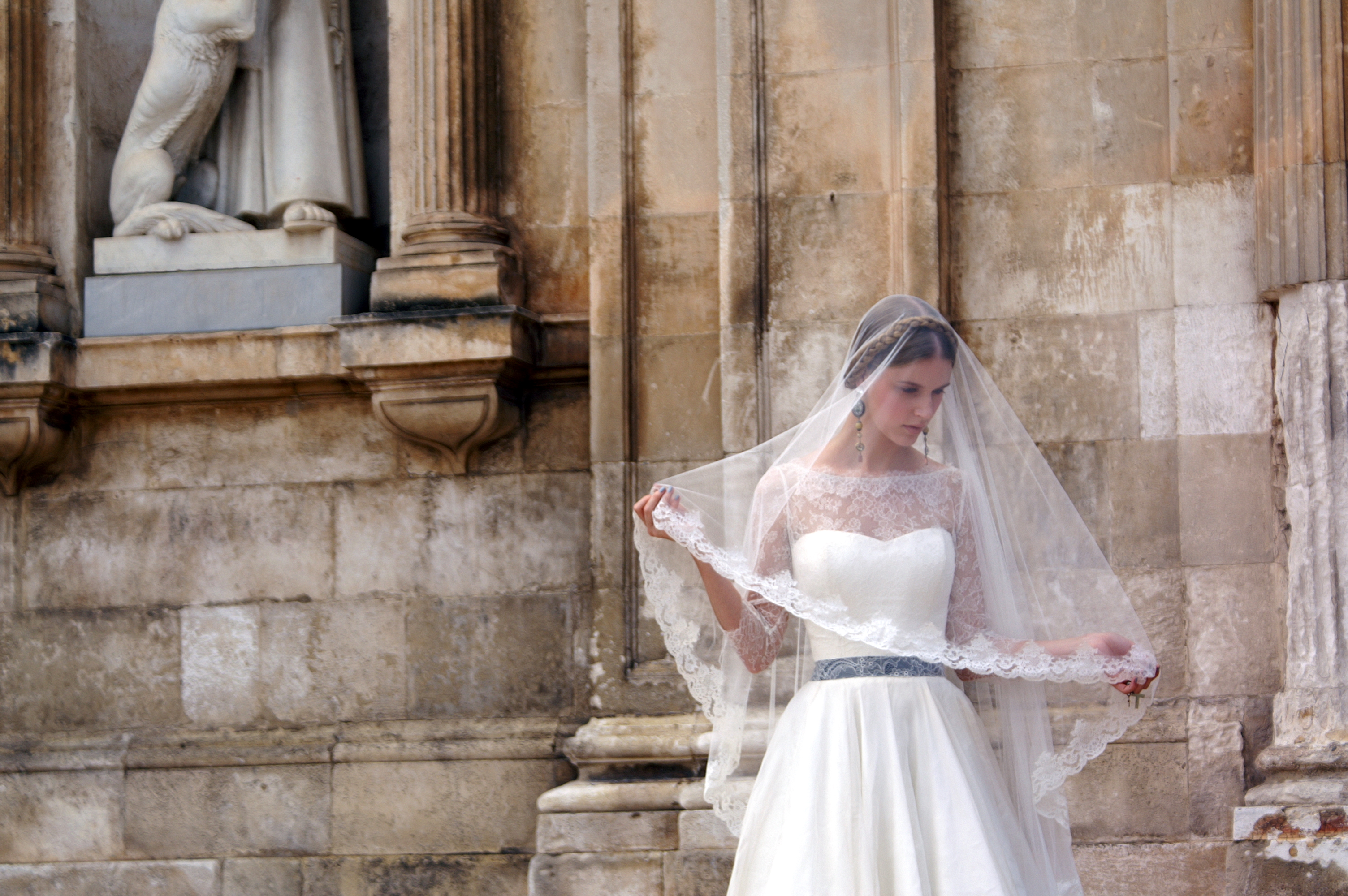 Model with white wedding dress in front of church in Ostuni, Puglia, Italy