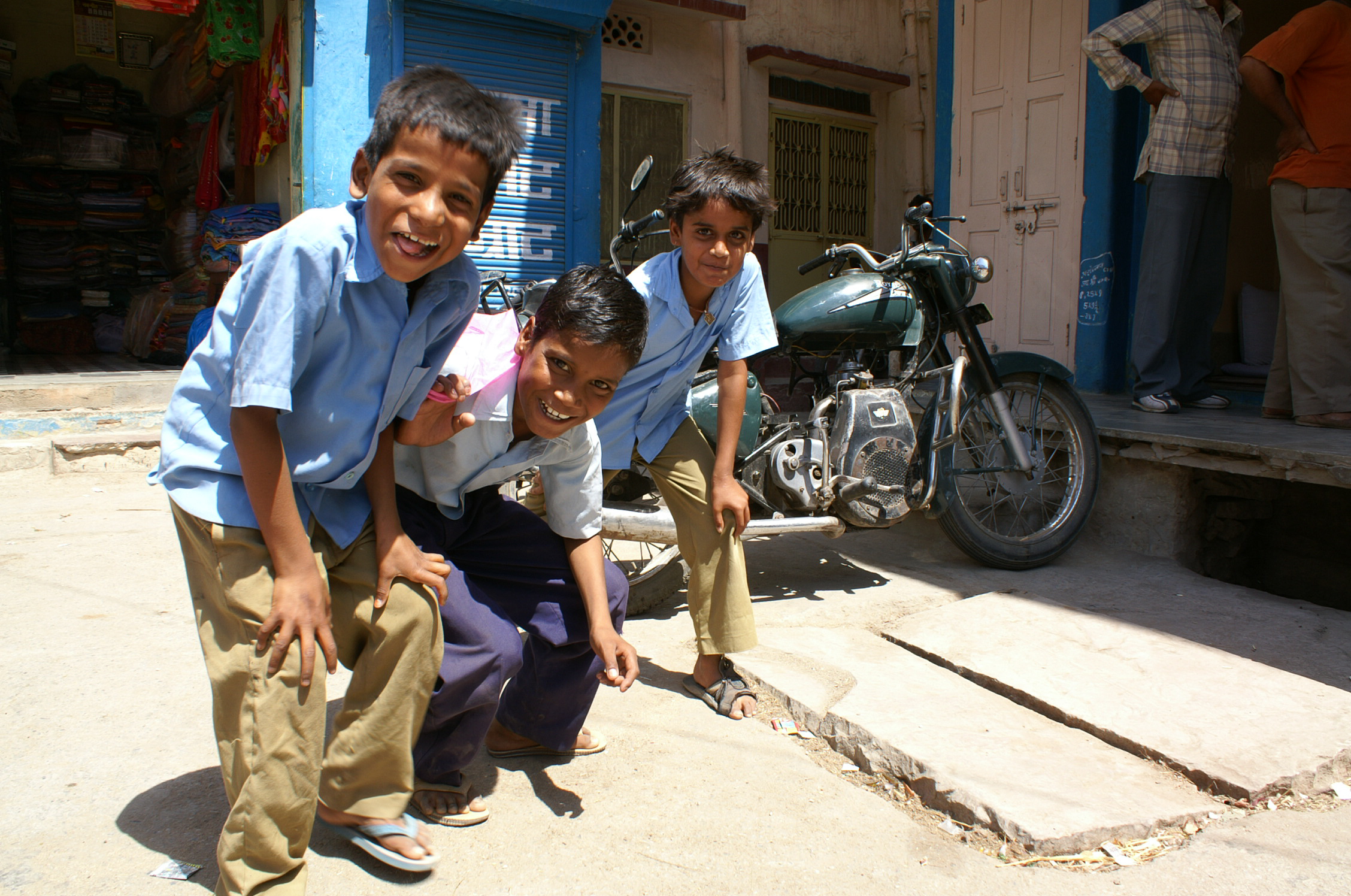 Boys posing in front of motorcycle in Rajasthan, India