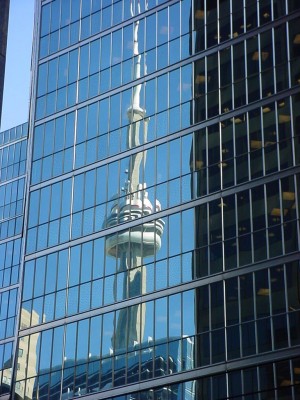 CN Tower reflecting in nearby office building's glass facade