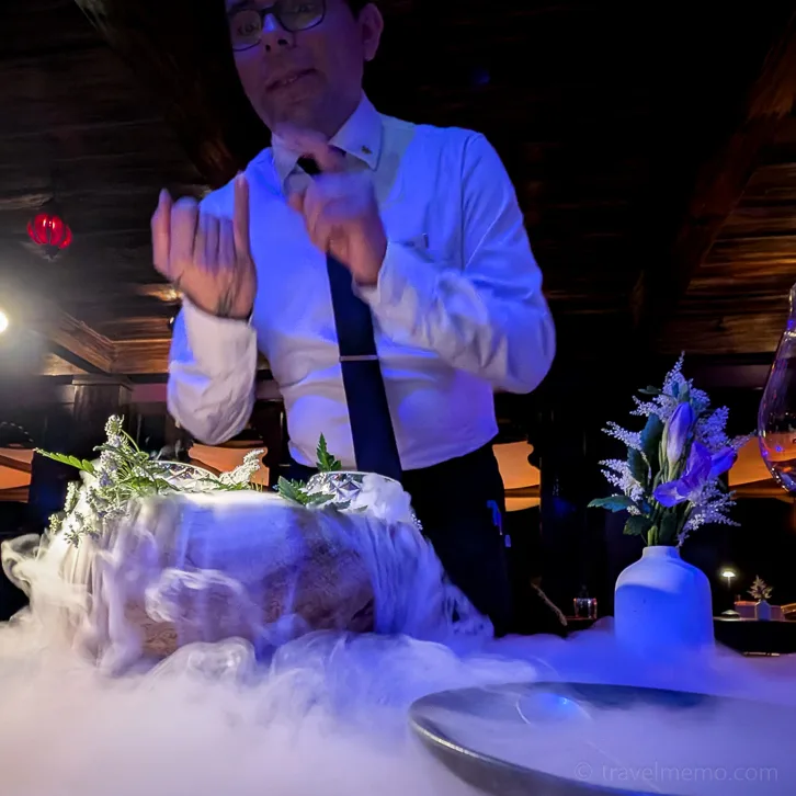 Amor Loco Restaurant in Nayara Gardens: waiter explains dish with steaming dry ice while white mist streams over the table