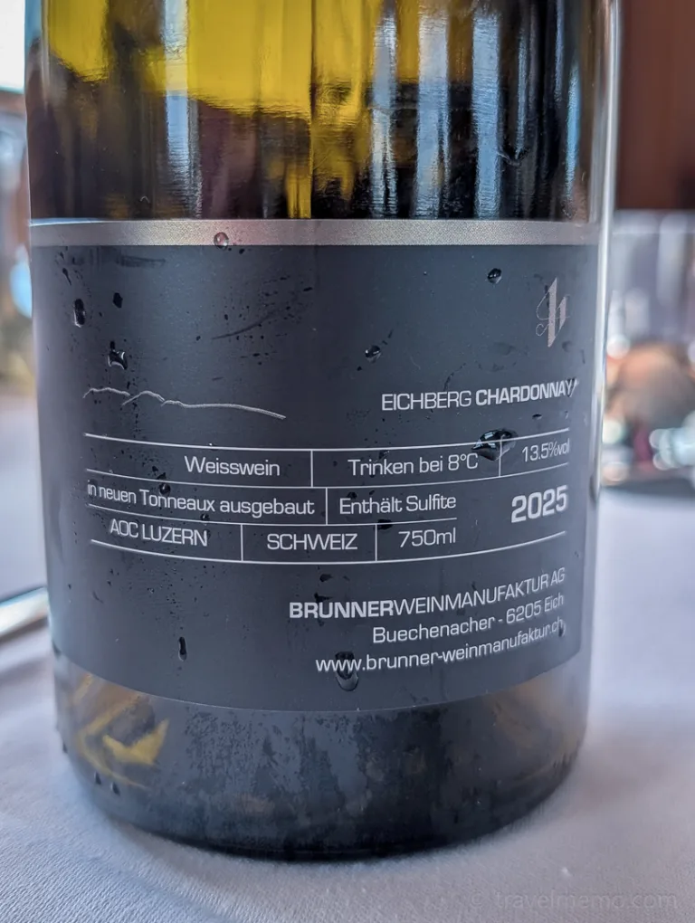 Label of a bottle of Eichberg Chardonnay from the Lucerne AOC, produced by Brunner Weinmanufaktur, on a set table