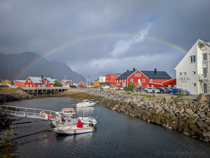 Rainbow over red Rorbuer fishing huts in Henningsvær
