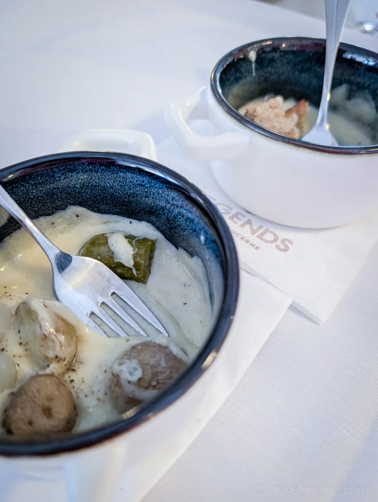 Two small bowls of regional stew with a creamy sauce, served on a white cloth napkin