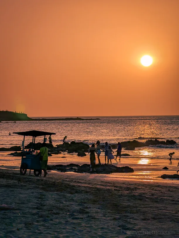 Sunset on Tamarindo beach with beach vendors and bathers in the warm evening light
